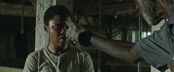 Movie still from “It” (2017), directed by Andy Muschietti – A man with a hand on his face and a man with a hand on his ear; Close Up shot, Over the shoulder angle