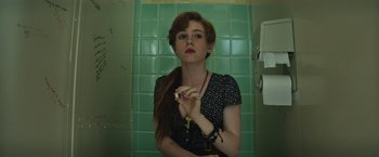 Movie still from “It” (2017), directed by Andy Muschietti – A woman holding a toothbrush in a bathroom; Close Up shot, Low angle