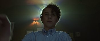 Movie still from “It” (2017), directed by Andy Muschietti – A young man with curly brown hair wearing a blue shirt; Close Up shot, Low angle