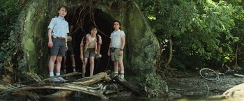 Movie still from “It” (2017), directed by Andy Muschietti – Two people standing next to each other in front of a tree; Medium shot, Low angle