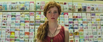 Movie still from “It” (2017), directed by Andy Muschietti – A woman standing in front of a wall of greeting cards; Close Up shot, Low angle