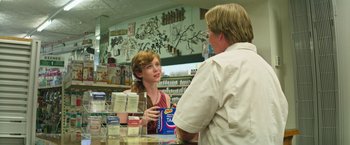 Movie still from “It” (2017), directed by Andy Muschietti – A woman is talking to a man in a store; Medium shot, Over the shoulder angle