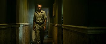 Movie still from “It” (2017), directed by Andy Muschietti – A man walking down the hall way of a house; Medium shot, Low angle