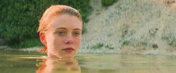 Movie still from “It” (2017), directed by Andy Muschietti – A woman in a body of water looking at the camera; Close Up shot, High angle