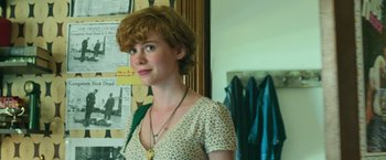 Movie still from “It” (2017), directed by Andy Muschietti – A woman with short red hair wearing a necklace; Close Up shot, Over the shoulder angle