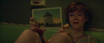 Movie still from “It” (2017), directed by Andy Muschietti – A woman looking at a picture on a mirror; Close Up shot, Low angle