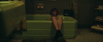 Movie still from “It” (2017), directed by Andy Muschietti – A woman sitting on the edge of a green bathtub; Medium shot, High angle