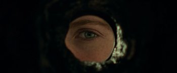 Movie still from “It” (2017), directed by Andy Muschietti – A man's eye is seen through a hole in a mirror; Extreme Close Up shot, Overhead angle