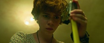 Movie still from “It” (2017), directed by Andy Muschietti – A woman with short brown hair holding a pair of scissors; Close Up shot, Low angle