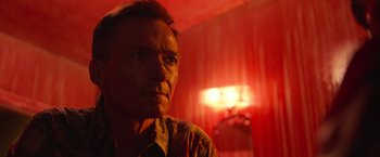 Movie still from “It” (2017), directed by Andy Muschietti – A person in a red room; Close Up shot, Low angle