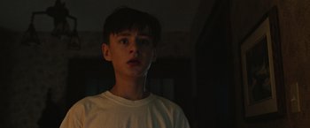 Movie still from “It” (2017), directed by Andy Muschietti – A young man in a white shirt is looking at the camera; Close Up shot, Low angle