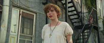 Movie still from “It” (2017), directed by Andy Muschietti – A young woman in a white dress with a key necklace; Close Up shot, Low angle