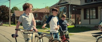 Movie still from “It” (2017), directed by Andy Muschietti – Three young boys riding bikes down a street; Medium shot, Low angle