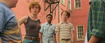 Movie still from “It” (2017), directed by Andy Muschietti – A group of people standing next to each other on a street; Medium shot, Low angle