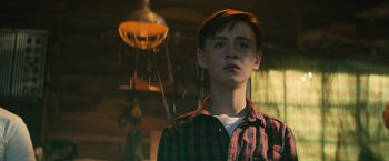Movie still from “It” (2017), directed by Andy Muschietti – A young man in a plaid shirt looking at the camera; Close Up shot, Low angle