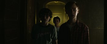 Movie still from “It” (2017), directed by Andy Muschietti – A group of young men standing in a hallway; Medium shot, Low angle