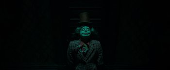 Movie still from “It” (2017), directed by Andy Muschietti – A man in a suit and top hat; Medium shot, Overhead angle