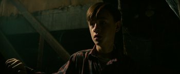 Movie still from “It” (2017), directed by Andy Muschietti – A young boy is looking at something in the dark; Close Up shot, Low angle