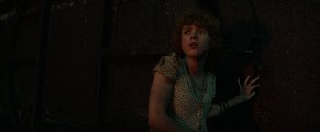 Movie still from “It” (2017), directed by Andy Muschietti – A woman with curly hair is standing in the dark; Close Up shot, Low angle