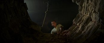 Movie still from “It” (2017), directed by Andy Muschietti – A man is climbing up the side of a wall; Medium shot, Low angle