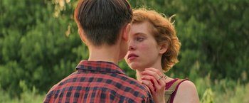 Movie still from “It” (2017), directed by Andy Muschietti – A man and a woman kissing in a field; Close Up shot, Over the shoulder angle