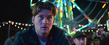 Movie still from “It Chapter Two” (2019), directed by Andy Muschietti – A young man looking into the distance at a carnival; Close Up shot, Low angle