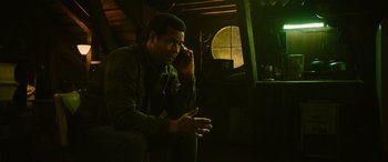 Movie still from “It Chapter Two” (2019), directed by Andy Muschietti – A man sitting on a chair talking on a phone; Medium shot, Low angle