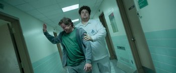 Movie still from “It Chapter Two” (2019), directed by Andy Muschietti – Two men in a hospital hallway , one of whom is holding his arm around the other; Medium shot, Low angle