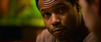 Movie still from “It Chapter Two” (2019), directed by Andy Muschietti – A man's face in front of a green background; Close Up shot, Over the shoulder angle