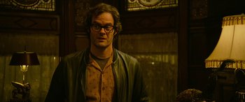 Movie still from “It Chapter Two” (2019), directed by Andy Muschietti – A man with glasses is standing in front of a window; Close Up shot, Over the shoulder angle