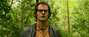 Movie still from “It Chapter Two” (2019), directed by Andy Muschietti – A man wearing glasses and a leather jacket looking at the camera; Close Up shot, Low angle