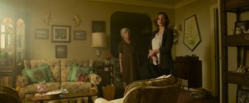 Movie still from “It Chapter Two” (2019), directed by Andy Muschietti – Two women standing in a living room holding a purse; Medium shot, Low angle