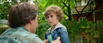 Movie still from “It Chapter Two” (2019), directed by Andy Muschietti – A young boy being held by a man in a park; Close Up shot, Over the shoulder angle