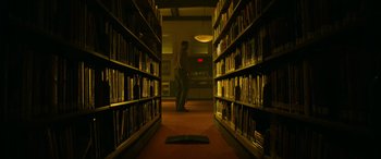Movie still from “It Chapter Two” (2019), directed by Andy Muschietti – A man standing in a room with a book; Wide shot, Low angle