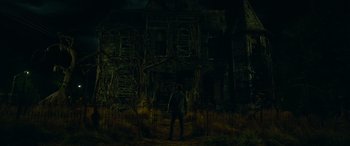 Movie still from “It Chapter Two” (2019), directed by Andy Muschietti – A man standing in front of a house at night; Wide shot, Low angle