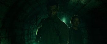 Movie still from “It Chapter Two” (2019), directed by Andy Muschietti – A man standing next to another man in a dark room; Medium shot, Low angle