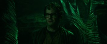 Movie still from “It Chapter Two” (2019), directed by Andy Muschietti – A man with glasses is standing in the dark; Close Up shot, Over the shoulder angle