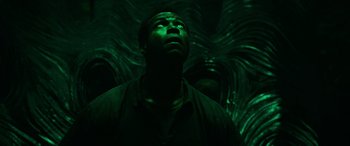 Movie still from “It Chapter Two” (2019), directed by Andy Muschietti – A man looking up in a dark room with green lighting; Close Up shot, Overhead angle