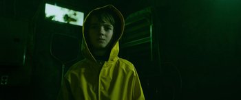 Movie still from “It Chapter Two” (2019), directed by Andy Muschietti – A young boy wearing a yellow raincoat in the dark; Close Up shot, Low angle