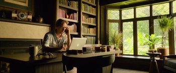 Movie still from “It Chapter Two” (2019), directed by Andy Muschietti – A woman sitting in front of an open laptop computer; Medium shot, High angle