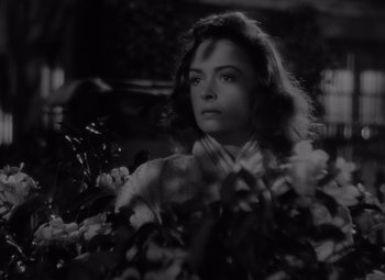 Movie still from “It's a Wonderful Life” (1946), directed by Frank Capra – A black - and - white photo of a woman in a garden; Close Up shot, High angle