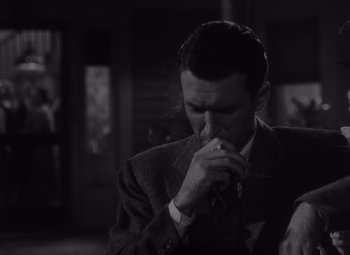 Movie still from “It's a Wonderful Life” (1946), directed by Frank Capra – A black and white photo of a man smoking a cigarette; Close Up shot, High angle