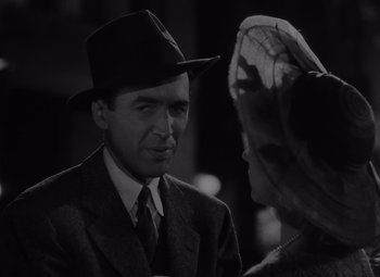 Movie still from “It's a Wonderful Life” (1946), directed by Frank Capra – A man in a suit and a hat talking to a woman in a hat; Close Up shot, Over the shoulder angle