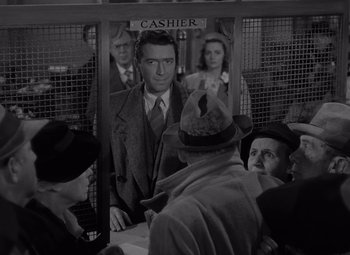 Movie still from “It's a Wonderful Life” (1946), directed by Frank Capra – An old photo of a man standing in front of a counter; Medium shot, Low angle