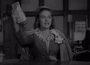 Movie still from “It's a Wonderful Life” (1946), directed by Frank Capra – A black and white photo of a woman holding a bunch of money; Medium shot, Low angle