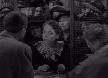 Movie still from “It's a Wonderful Life” (1946), directed by Frank Capra – A group of people gathered around a table; Medium shot, Over the shoulder angle