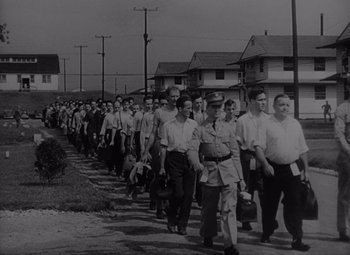Movie still from “It's a Wonderful Life” (1946), directed by Frank Capra – A black and white photo of a group of men walking down a street; Wide shot, High angle
