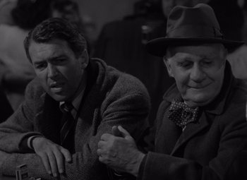 Movie still from “It's a Wonderful Life” (1946), directed by Frank Capra – Two older men in suits and hats are sitting together; Close Up shot, Over the shoulder angle
