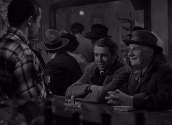 Movie still from “It's a Wonderful Life” (1946), directed by Frank Capra – A group of men sitting at a bar talking to each other; Medium shot, Over the shoulder angle