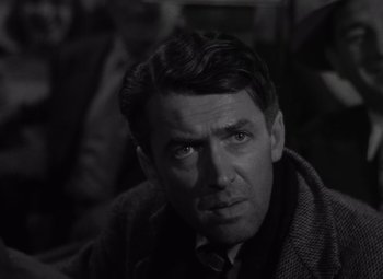 Movie still from “It's a Wonderful Life” (1946), directed by Frank Capra – A man in a black and white photo looking at the camera; Close Up shot, Over the shoulder angle